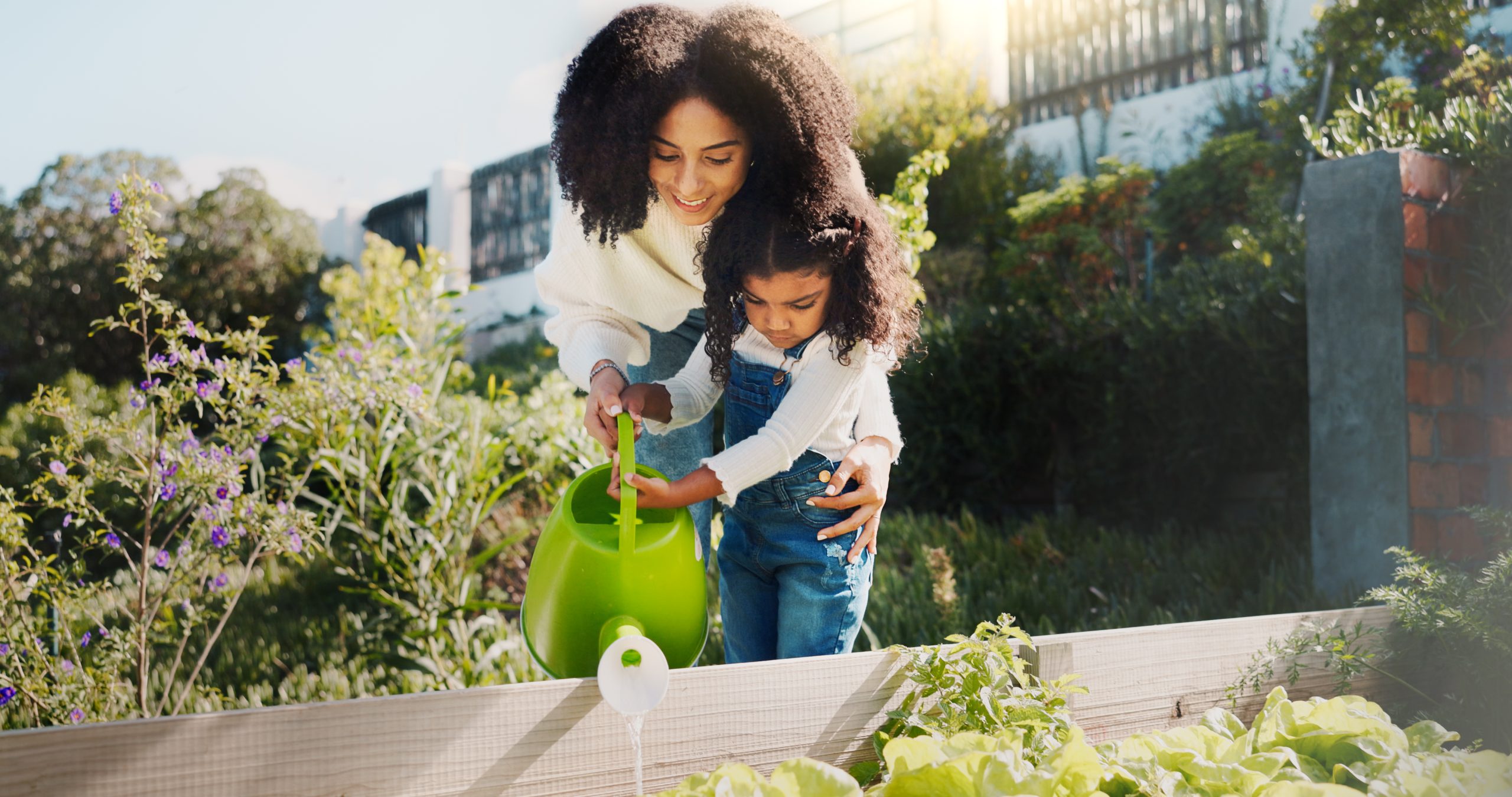 Gardening, water and mom with child in backyard for planting flowers, learning skills and landscaping. Family, nature and mother with girl together outdoors with plants for growth, hobby and relax Gardening, water and mom with child in backyard for planting flowers, learning skills and landscaping. Family, nature and mother with girl together outdoors with plants for growth, hobby and relax